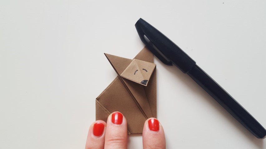 Origami Fuchs Schritt 11 Mund und Augen mit einenn schwarzen Stift anmalen Hand im Glück