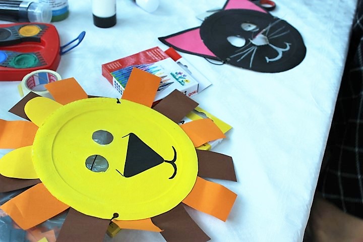 Löwen-Maske aus Pappteller auf dem Tisch Kinderfest Hammer Park Hand im Glück